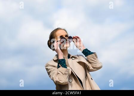Young beautiful businesswoman with sunglasses, phone, laptop, cup of coffee in the city street Stock Photo