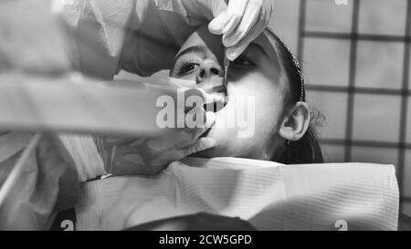 Young caucasian girl caring about her teeth. Portrait of charming girl sitting in dentist chair. Stock Photo