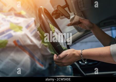 Detailing service, preparing leather steering wheel for painting, female worker hands wipes steering wheel with fine sandpaper, restoring and care leather car interior. Stock Photo