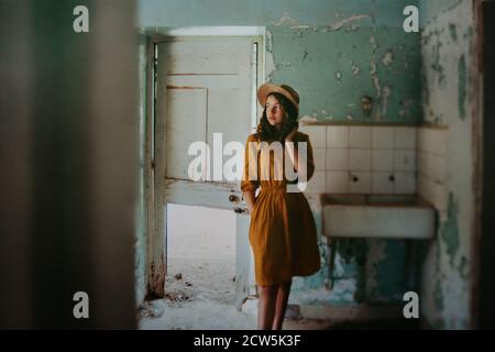 Girl in old derelict building with hat on Stock Photo