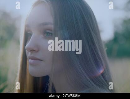 Close-up of the face of a young woman at dusk in the forest. Stock Photo