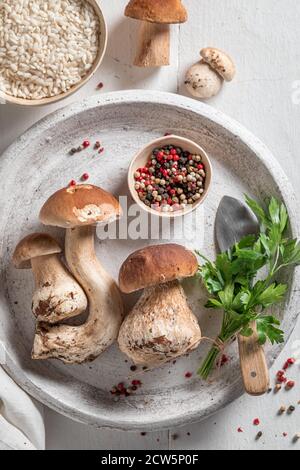 Preparations for vegetarian risotto with boletus mushrooms and parsley on wooden table Stock Photo