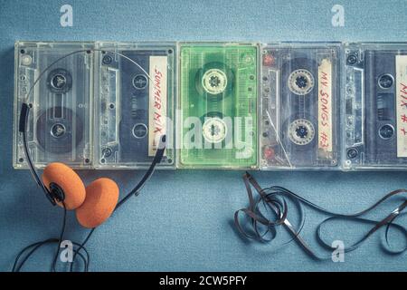 Several old audio cassettes with orange headphones on blue sofa Stock Photo