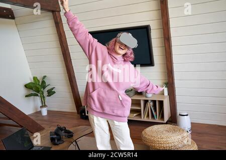 Excited woman wear vr headset flying experiencing virtual reality game. Stock Photo