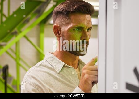 Portrait of handsome bearded man using control panel while operating self storage unit, copy space Stock Photo