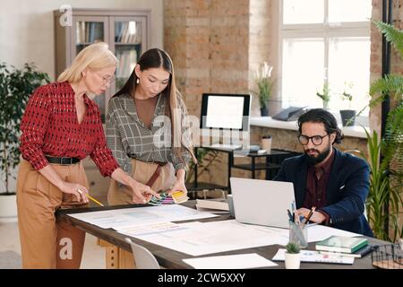 Two creative female designers choosing color for new mobile application Stock Photo