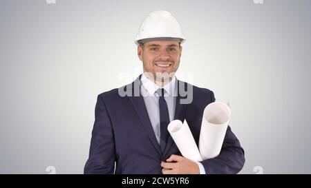 Smiling architect or engineer walking while keeping projects in Stock Photo