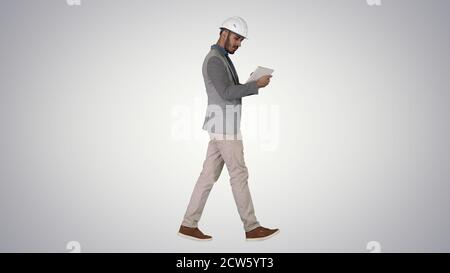 Engineer walking and working on digital tablet on gradient backg Stock Photo