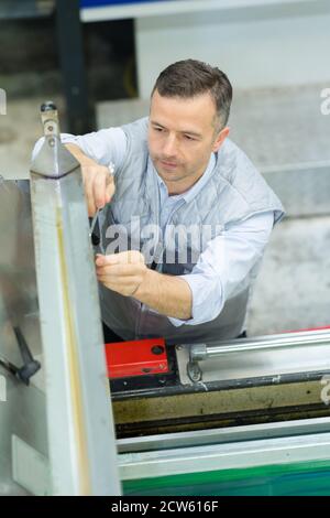worker removing dirt from paper in factory Stock Photo