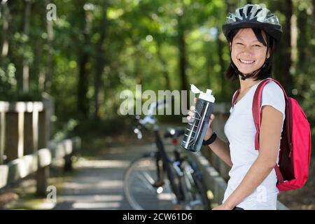 active woman with bike drinking cold water Stock Photo