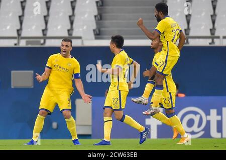 Doha, Qatar. 27th Sep, 2020. Abderazak Hamdallah (L) of Al Nassr celebrates scoring during the AFC Asian Champions League round of 16 football match between Taawoun FC and Al Nassr of Saudi Arabia at Education City Stadium in Doha, Qatar, Sept. 27, 2020. Credit: Nikku/Xinhua/Alamy Live News Stock Photo