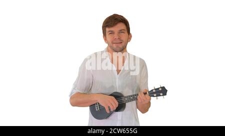 Young man playing ukulele and signing while walking and looking Stock Photo