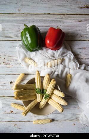 Healthy fresh baby corns with bell peppers on a background Stock Photo