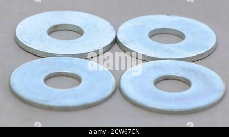 Four Flat metal washers on gray background Stock Photo
