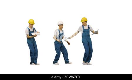 Three young construction workers in hardhats passing on document Stock Photo