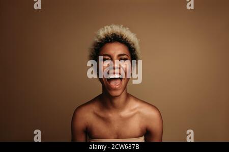Close up of laughing african american woman. Portrait of happy curly haired woman. Stock Photo