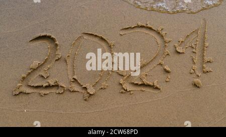 The inscription at the sand. 2021 year. Concept of coming New Year. Stock Photo