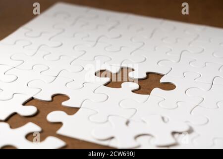 White jigsaw puzzle on the table. Stock Photo