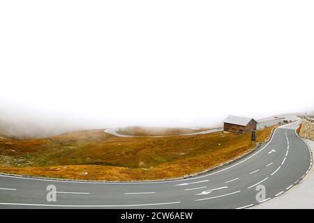 Foggy autumn morning on a winding road high in the mountains. Danger Stock Photo