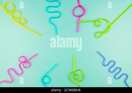 multicolored plastic cocktails straws on blue background. Stock Photo
