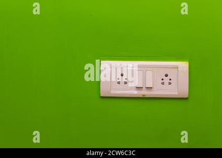 Double Sockets for electrical appliances on a green wall background. all purpose switch on a wall socket. Stock Photo