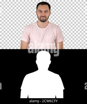 Young happy man in t-shirt smiling at camera and walking, Alpha Stock Photo