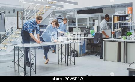 In the Busy Engineering Agency: Diverse Group of Engineers, Technicians, Working on Design for Industrial Engine Prototype. Specialists Talk During Stock Photo