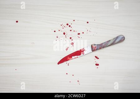 Bloody knife on the floor. knife was found at the scene of the crime. A forensic takes blood samples from the knife. Bloody knife lies on ceramic tile Stock Photo
