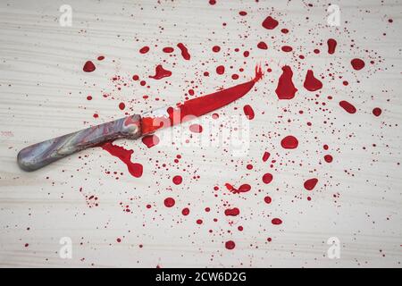 Bloody knife on the floor. knife was found at the scene of the crime. A forensic takes blood samples from the knife. Bloody knife lies on ceramic tile Stock Photo