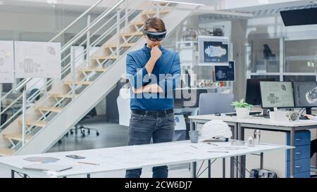 Engineering Software Developer Wearing Virtual Reality Headset Uses Gestures to Interact with Augmented Reality while Designing Industrial Engine Stock Photo