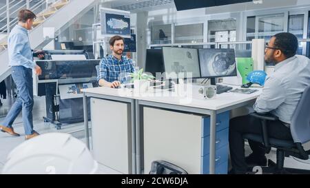 In the Busy Engineering Facility: Diverse Group of Engineers, Technicians, Specialists Working on Design for Industrial Engine Prototype Stock Photo