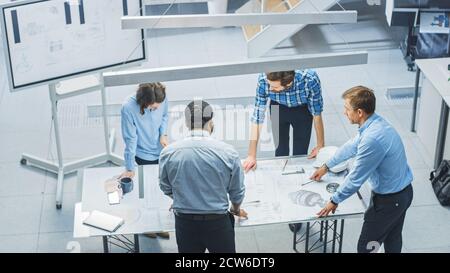 In Busy Engineering Facility: Diverse Group of Engineers, Technicians, Specialists Working on Design for Industrial Engine Prototype. Professionals Stock Photo