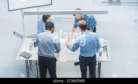 In Busy Engineering Facility: Diverse Group of Engineers, Technicians, Specialists Working on Design for Industrial Engine Prototype. Professionals Stock Photo