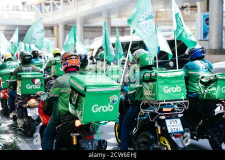 Bangkok, Thailand - August 24, 2020 : Group of Grab riders riding a motorbike doing their services. Grab is a multinational ride-hailing company that offers food delivery and digital payment services. Stock Photo