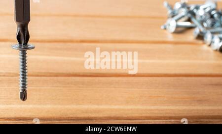 A screwdriver and self-cutters on a brown wooden background. Building tools to repair the house Stock Photo