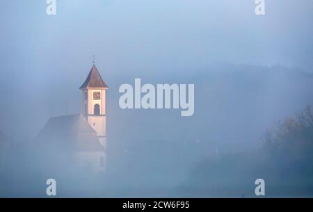 Riedlingen Zell, Germany. 28th Sep, 2020. Only the steeple of the church St. Gallus is visible from the village Zell, which is situated on the Danube. At single-digit temperatures, ground fog has formed in the morning. Credit: Thomas Warnack/dpa/Alamy Live News Stock Photo