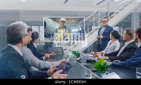 In the Conference Room Group of Directors, Investors and Businessmen Making Video Conference Call To Talk with Professional Female Engineer working in Stock Photo