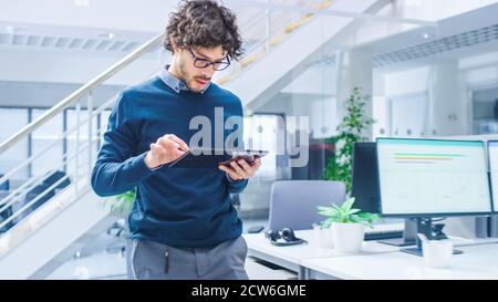 In Bright Modern Office: Beautiful Office Worker Walking and Using Digital Tablet Computer. Young Businessmen Planning and Solving Problem. Stock Photo