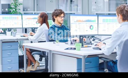 In the Modern Open Space Office Businessmen and Businesswomen Working on Desktop Computers with Financial Graphs and Charts. Stock Photo