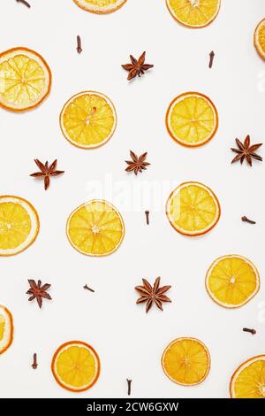 Pattern of cloves, anise and dried oranges on white background. Christmas or New Year backdrop Stock Photo