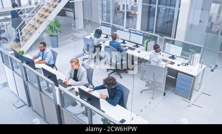 Diverse Multinational Team of Business Managers and Specialists Work on Desktop Computers, Have Discussion with Colleagues. Young and Motivated Stock Photo