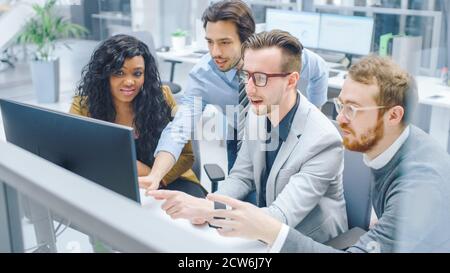 In Modern Office: Diverse Team of Businessmen and Businesswoman Work on Computer, Having Discussion, Successfully Finding Problem, Applaud and Stock Photo