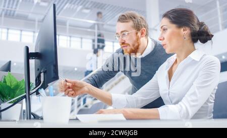 Beautiful Businesswoman Uses Desktop Computer, Consults Her Project Manager about Documents with Graphs and Statistics. Teamwork in the Background Big Stock Photo