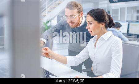 Beautiful Businesswoman Uses Desktop Computer, Consults Her Project Manager about Documents with Graphs and Statistics. Teamwork in the Background Big Stock Photo
