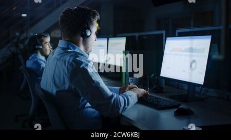 Late at Night In Modern Office: Row of Ambitious Businessmen and Businesswomen Working at their on Desktop Computers, Finishing Important Project Stock Photo