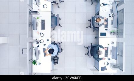 Top Down Shot of Big Busy Corporate Office with Tow Rows off Businessmen and Businesswomen Working on Desktop Computers. Bright Open Space Office with Stock Photo