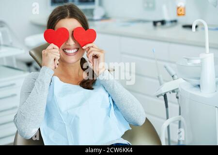 Attractive adult woman in dentist office with hearts Stock Photo