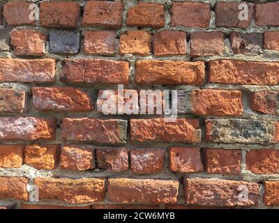A full frame red brick wall background with worn and weathered bricks and grunge texture with copy space Stock Photo