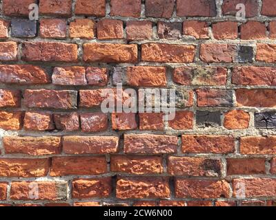 A full frame red brick wall background with worn and weathered bricks and grunge texture with copy space Stock Photo