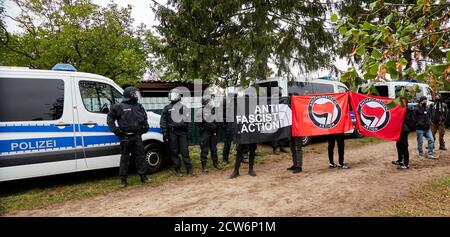 Eschede, Germany, September 26., 2020: Demonstrators with an antifascist poster stand next to black uniformed policemen and hold their poster into the Stock Photo